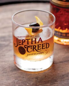 Jeptha Creed Old Fashioned Cocktail on bourbon barrel.