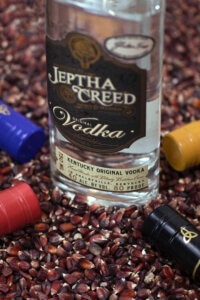 Jeptha Creed Original Vodka resting on Bloody Butcher Corn with flavored vodkas surrounding