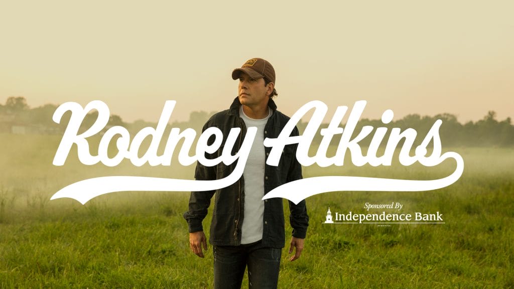 Photo of Rodney Atkins in a field with text of his name and "Sponsored by Independence Bank" laid overtop.